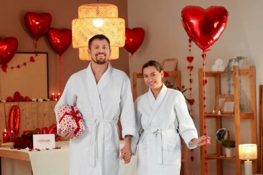 Sevgililer Günü 'nde hediye ve balonla kaplıca salonunda genç bir çift.