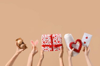 Kaplıca malzemeleri ve bej arka planda hediye alan kadın eller. Sevgililer Günü kutlaması