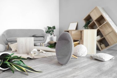 Depremden sonra mobilyaların devrildiği dağınık bir oturma odası.