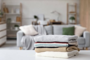 Katlanmış kışlık giysiler masanın üstünde, yakın plan.