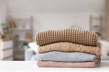 Katlanmış kışlık giysiler masanın üstünde, yakın plan.