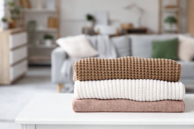 Katlanmış kışlık giysiler masanın üstünde, yakın plan.