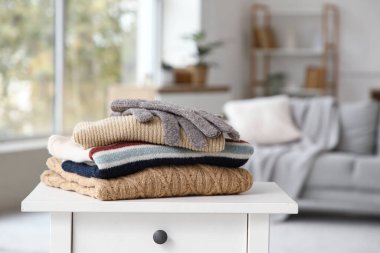 Katlanmış kışlık giysiler masanın üstünde, yakın plan.