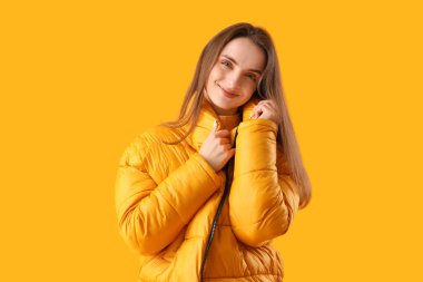 Sarı arka planda şık ceketli güzel bir kadın.