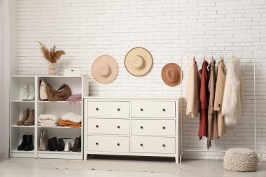 Kadın kıyafetleri, ayakkabıları ve aksesuarları olan şık bir soyunma odası.