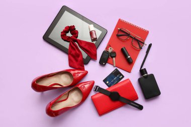 Renkli arka planda şık kadın aksesuarları, ayakkabıları, modern aletleri ve araba anahtarlarıyla kompozisyon