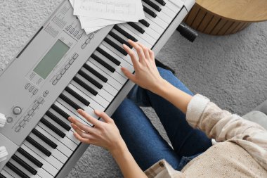 Evde sentezleyici çalan kadın, üst görünüm