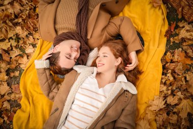 Güzel, sevgi dolu, mutlu bir çift sonbahar parkında yatıyor.