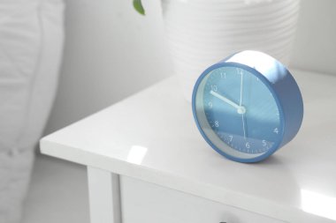 Mavi çalar saat ve bitki yatak odasında, yakın plan.