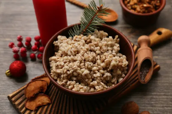 Bir kase geleneksel Ukrayna Kutya yemeği köknar dalı ve ahşap arka planda Noel topu, yakın plan