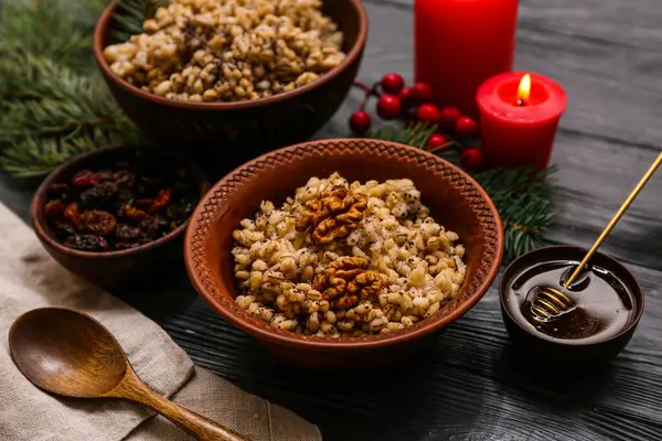 Geleneksel Ukrayna Kutya tabakları Noel ağacı dalları ve siyah ahşap arka planda yanan mumlar.