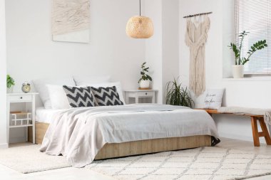 Masalar, banklar ve bitkilerle aydınlık yatak odasının içi