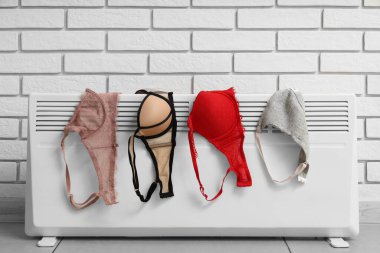 Kaloriferin yanında farklı sutyenler kurutuluyor.