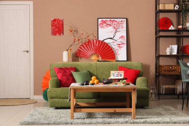 Çin Yeni Yıl kutlamaları için yeşil kanepe, masa ve dekorla oturma odasının içinde.