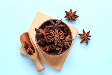 Ahşap kase ve aromatik yıldız anason arkaplanlı kepçe