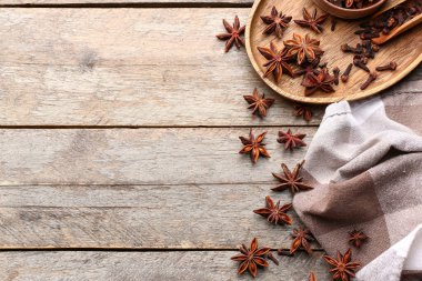 Ahşap zemin üzerinde aromatik yıldız anason, karanfil ve peçete kompozisyonu