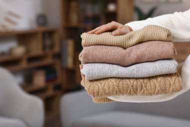 Kadının elinde kışlık giysiler var, yakın plan.