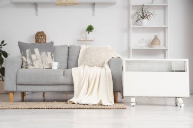 Işıl ışıl oturma odasındaki kanepenin yanındaki elektrikli konveyör ısıtıcısı.