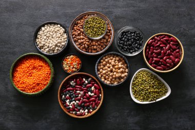 Koyu arkaplanda farklı ham baklagiller içeren kompozisyon