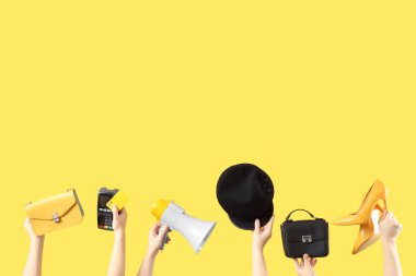 Ödeme terminali olan kadın eller, megafon ve sarı arka planda aksesuarlar. Kara Cuma İndirimi