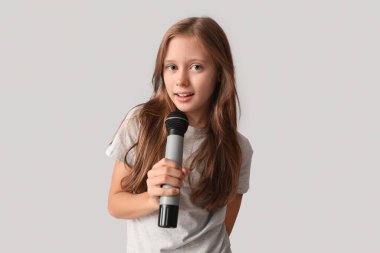 Gri arka planda modern mikrofonu olan tatlı bir kız.