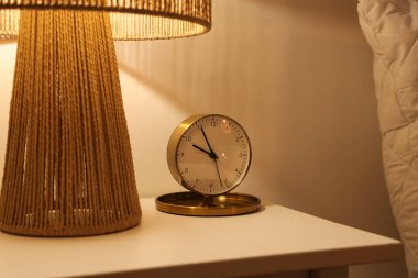 Geceleri yatak odasındaki lambalı çalar saat, yakın plan.