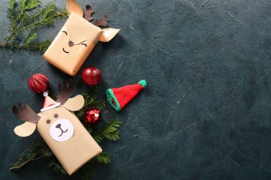 Güzel hediye kutuları, köknar dalları ve karanlık arka planda Noel baloları.