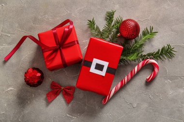 Gri grunge arka planında hediye kutuları, Noel baloları ve köknar dalları olan güzel kompozisyon