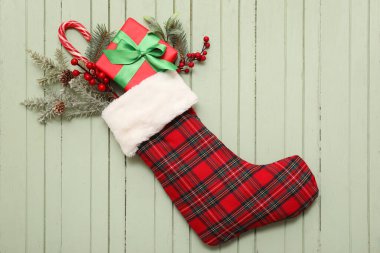Yeşil ahşap arka planda dekorlu Noel çorabı. Üst görünüm