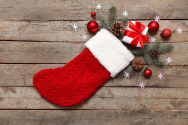 Gri ahşap arka planda süslemeleri olan Noel çorabı. Üst görünüm