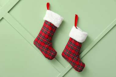 Yeşil duvarda asılı Noel çorapları