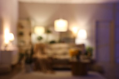 Oturma odasının içinde rahat bir kanepe ve geceleri çiçekli kahve masası. Bulanık görünüm