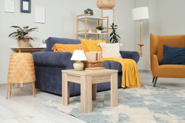 Oturma odasında rahat bir kanepe, sehpa ve koltuk var.