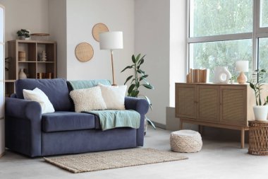 Oturma odasının içinde yastıklı ve ekoseli rahat bir kanepe.