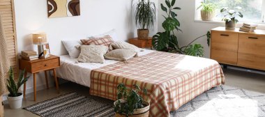 Ev bitkileriyle dolu güzel, modern bir yatak odası.