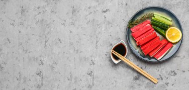 Lezzetli yengeç çubukları ve grunge arkaplanda soya soslu tabak, metin için yer, üst görünüm