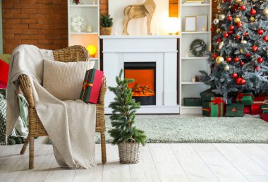 Hasır koltuğu, Noel ağacı ve hediye kutusuyla şenlikli oturma odasının içinde.