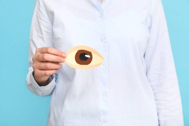 Renkli arka planda kağıt insan gözü tutan kadın, yakın plan