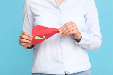 Renkli arka planda kağıt karaciğer tutan kadın, yakın plan