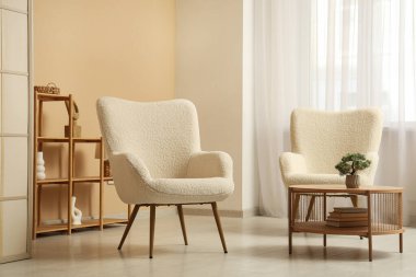 Rahat koltukları olan modern oturma odasının şık iç mekanı.