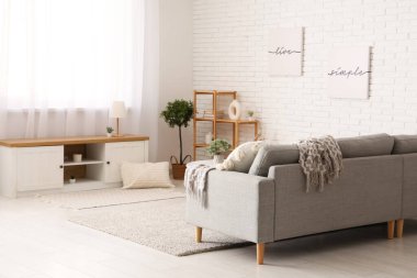 Rahat kanepe, bank, sehpa ve raf ünitesi olan bir oturma odası.