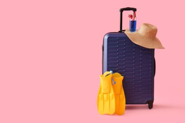 Paletli bavul, pembe arka planda şapka ve kokteyl.