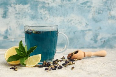 Bir fincan kelebek arkaplanda bezelye çiçeği çayı, yakın plan.