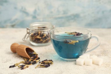 Bir fincan kelebek arkaplanda bezelye çiçeği çayı, yakın plan.