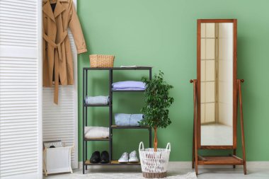 Aynalı, raflı ve katlanabilir ekranlı şık bir oda.