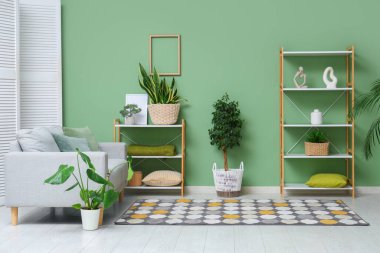 Oturma odasında rahat bir kanepe, heykel, saksı ve raf ünitesi var.