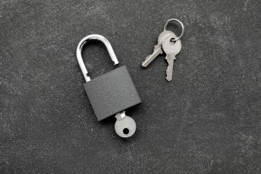 Koyu grunge arkaplanda anahtarlı asma kilit
