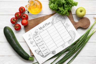 Sağlıklı ürünler ve beyaz ahşap arka planda haftalık yemek planı. Diyet kavramı