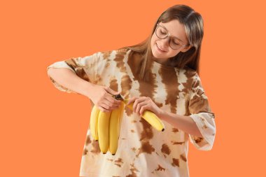 Turuncu arka planda muzları olan genç bir kadın.