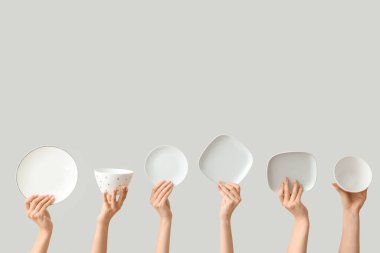 Açık arkaplanda boş tabakları tutan eller